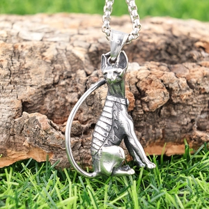 Vintage stainless steel Sphinx cat pendant necklace on natural outdoor green grass