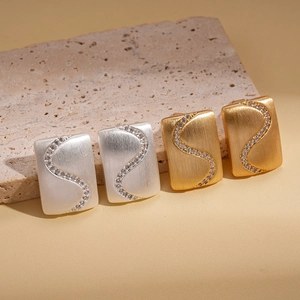 18K gold plated zircon square earrings in gold and silver set on stone display