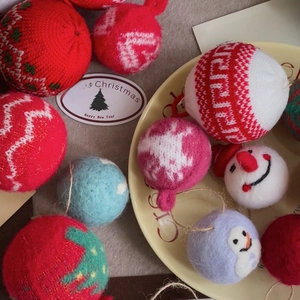 Detail of red knitted Christmas balls and wool felt snowman ornaments for tree decor