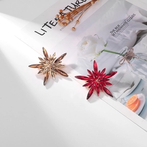 Detailed close-up of champagne and ruby starburst brooches with marquise crystal petals