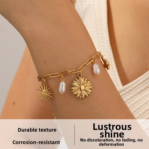 Détail du bracelet chaîne doré avec breloques tournesol, soleil et perles en goutte