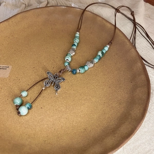 Detail of handcrafted ethnic necklace with turquoise beads and butterfly pendant