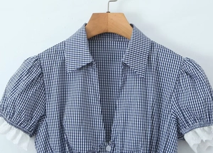 Detail of blue and white plaid shirt with delicate white lace trim on short sleeves