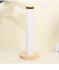 Close-up of a white velvet hair tie display stand with solid wood base and gold metal cap