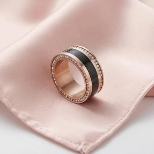 Detailed close-up of rose gold stainless steel ring with double-row crystals on pink silk