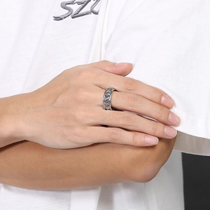 Detail shot of a vintage silver gothic ring featuring an intricate cross relief on a finger