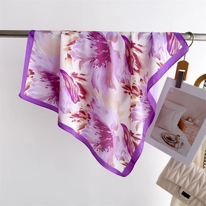 Detail of floral purple silk scarf hanging on a metal rack showing fabric texture