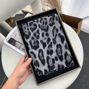 Detailed view of leopard print voile scarf in an elegant gift box with lifestyle decor