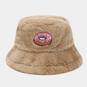 Close-up of beige plush bucket hat featuring a colorful pink donut embroidery patch
