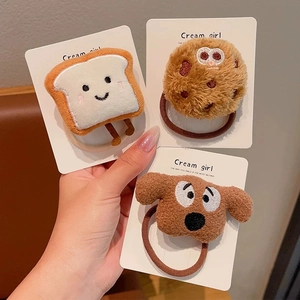 Close-up of plush hair ties featuring cartoon toast, cookie, and dog characters
