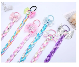 Détail de tresses colorées avec des élastiques licorne et nœuds papillon pour filles