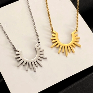 Gros plan détaillé des colliers soleil or et argent avec des pendentifs métalliques
