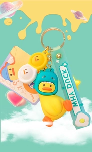 Gros plan du porte-clés canard jaune avec costume de dinosaure et breloque cacahuète