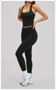 Détail d'un ensemble de yoga noir avec haut court à col en U et legging taille haute