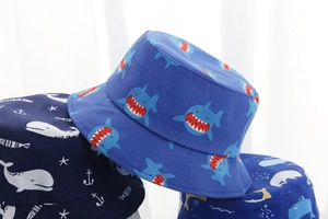 Close-up of baby bucket hats with cute blue ocean shark and whale prints in cotton
