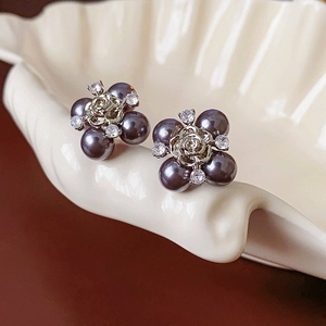 Macro view of flower earrings with dark grey pearls and sparkling zircon stones