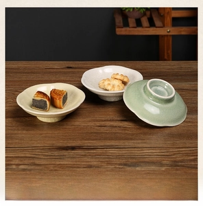Detailed close-up of crackle glaze ceramic snack plates with elegant footed base