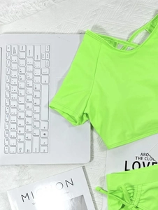 Detailed view of neon green two-piece bikini featuring short sleeves and back lace-up design