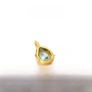 Macro shot of 12x7mm water-drop light blue gemstone pendant in gold stainless steel