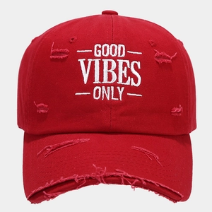 Close-up of red distressed baseball cap with Good Vibes Only white embroidery