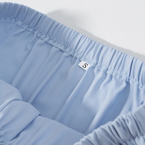 Detail of light blue elastic waistband with Size S label and precise stitching on shorts