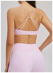 Détail d'un ensemble de yoga rose pâle avec fines bretelles croisées au dos