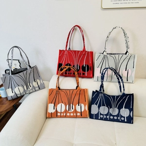 Vertical textured knit tote bags displayed in five colors including grey and red on a sofa