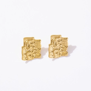 Macro detail of gold-plated titanium steel earrings with irregular lava texture