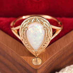 Eleganter roségoldener Tropfen-Opalring mit Vintage-Gravur auf einer Samtbox