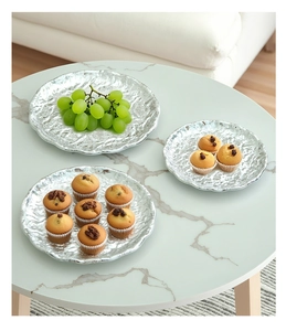 Close-up of hammered silver metal serving trays featuring artistic irregular edges