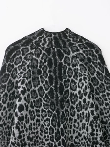 Detailaufnahme der Leopardenmuster-Stricktextur und des Halsausschnitts vom Pullover