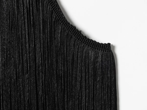 Detailaufnahme des schwarzen Neckholder-Tops mit dichten Falten und weichem Samtstoff