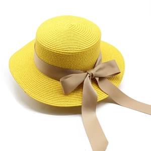 Dettaglio della trama in paglia e del grande fiocco di raso su un cappello di paglia