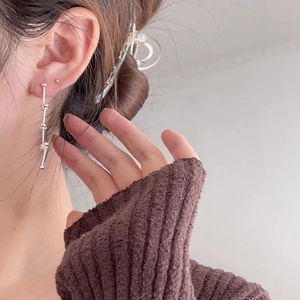 Close-up of elegant long sterling silver beaded drop earrings worn with a cozy sweater