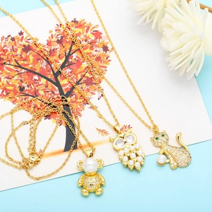 Detail of gold alloy animal pendants with faux pearls and sparkling cubic zirconia stones