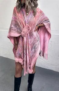 Detail view of pink knit shawl with faux fur collar and decorative tassel pom-poms