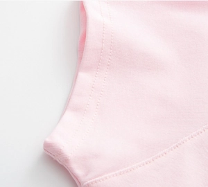 Gros plan des coutures de qualité et de la texture en maille rose clair du t-shirt