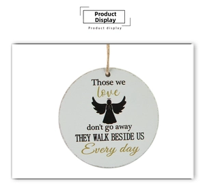 Close-up of a circular wooden Christmas ornament with angel silhouette and poem