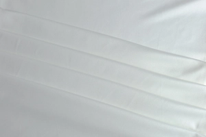 Close-up of white elegant metallic pleats and high-density fabric texture of the dress