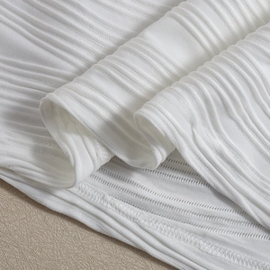 Close-up of white ribbed knit fabric texture and high-quality stitching details