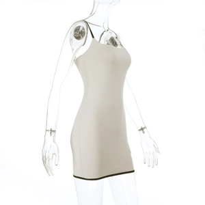 Detail eines beigen Mini-Bodycon-Kleids mit dünnen Trägern und schwarzen Kontrastpaspeln