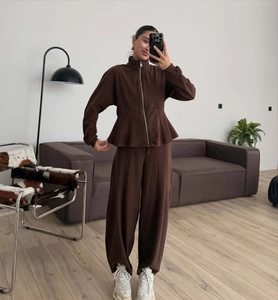 Detail of chocolate brown zip-up ruffle sweatshirt and high waist wide leg pants set