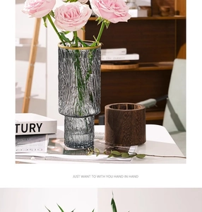 Close-up of grey textured glass vase with gold rim holding pink roses for home decor