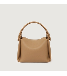 Detail of camel colored litchi grain leather handbag with minimalist handle design