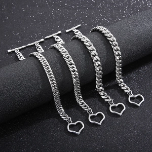 Detailed view of silver 8mm Cuban chain bracelets with heart charms and OT toggle clasp