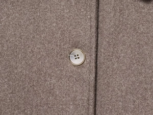 Detailed macro view of brown wool fabric texture and high-quality four-hole button