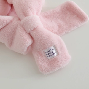 Macro shot of pink plush faux fur material with a decorative woven HELLO NICE DAY label