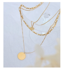 Close-up of triple-layered 18K gold plated titanium steel necklace with a round pendant