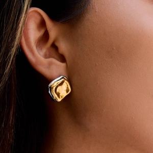 Macro shot of 18K gold and silver two-tone square earrings with hammered texture