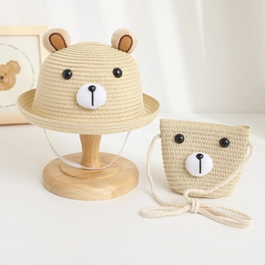 Close-up of baby straw hat and matching bear bag set with cute 3D bear ears and facial detail